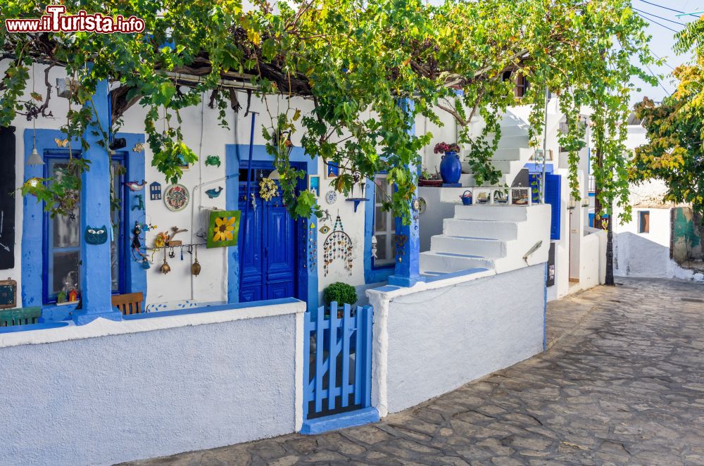 Immagine Architettura tipica in un villaggio dell'isola di Lipsi, Grecia, con dettagli blu e azzurri di porte, finestre e vasellame.