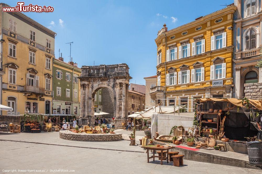 Immagine L'arco di trionfo (Golden Gate) e la piazza decorata per le Giornate dell'Antichità a Pola, Croazia. Denominata Pola Superiorum, questa manifestazione di tre giorni rievoca e risveglia i monumenti cittadini dell'epoca romana: il tempio di Augusto nel Forum romano, l'arco dei Sergi in piazza Port'Aurea e l'anfiteatro Arena. Danze, poesie e piatti dell'antica cena romana sono protagonisti di questa fiera - © Romas-Vysniauskas / Shutterstock.com