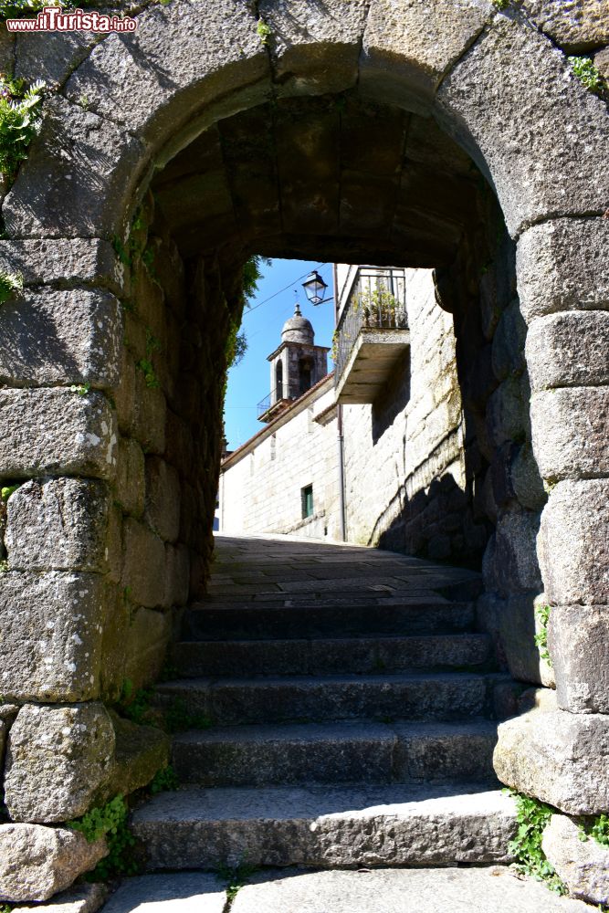 Immagine Arco nelle mura medievali di Ribadavia, Spagna. Sullo sfondo, una chiesetta.