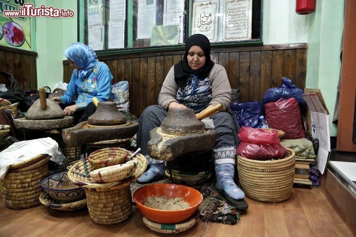 Immagine Lavorazione dell'argan a Marrakech, Marocco - Alcune donne intente alla preparazione dell'olio di argan prodotto dai frutti dell'argania, un albero dai rami spinosi particolarmente resistente e che può vivere sino a 150-200 anni. Questa pianta si è adattata perfettamente all'aridità del sudovest del Marocco e si presenta con una chioma ampia e arrotondata, tronco nodoso, tortuoso e spesso formato da più parti intrecciate fra loro