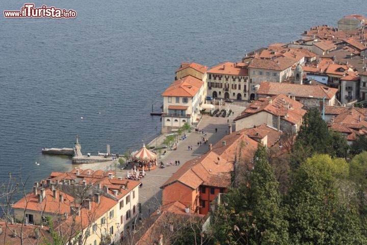 Immagine Una veduta aerea di Arona e il lago Maggiore, Piemonte - Situata sulla sponda piemontese del lago Maggiore e attraversata dal torrente Vevera, Arona dista circa 37 chilometri da Novara e una trentina da Varese e dall'aeroporto di Milano Malpensa. Attorno alla città piemontese si estendono bassirilievi di origine morenica; la maggior parte del territorio del comune è collinare con altitudini che vanno progressivamente dai 500 metri di Motto Mirabello ai 195 in riva al lago © marcovarro / Shutterstock.com