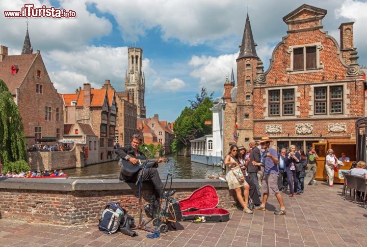 Immagine Artisti di strada al Rozenhoedkaai di Bruges, Belgio - Romantica città medievale delle Fiandre, Bruges è uno dei siti turistici più visitati di tutto il Belgio complice anche il suo suggestivo centro storico dichiarato Patrimonio Mondiale dell'Unesco. Musei e edifici storici rappresentano le attrazioni di questo luogo suggestivo conosciuto anche come Venezia del Nord per via dei tanti canali che attraversano la città. E come tutti i luoghi turistici anche Bruges ospita lungo le sue vie storiche, che qui si affacciano proprio sui corsi d'acqua, artisti di strada che con la loro arte ne rallegrano l'atmosfera © Renata Sedmakova / Shutterstock.com