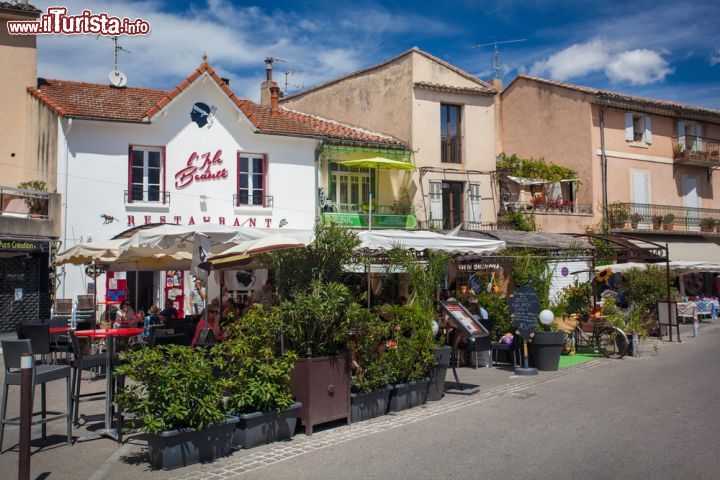 Immagine L'atmosfera rilassata di L'Isle-sur-la-Sorgue invita i visitatori a sedersi ai tavoli lungo le strade e i canali della città - foto © Ivica Drusany / Shutterstock.com