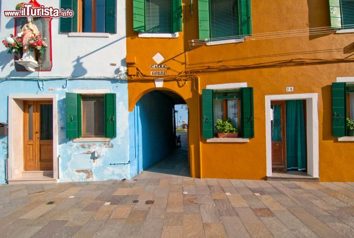 Immagine Attraverso la calle nei luoghi di Burano, la più colorata delle isole della Laguna di Venezia - Burano fa parte del gruppo di piccole isole che compongono la bellissima Laguna Veneta. A pochi minuti di Vaporetto da Venezia, la regina della Laguna, Burano si presenta come un piccolo mondo senza tempo, fatto di case colorate, merletti e biscotti fatti a mano, da percorrere attraverso calli e ponticelli.- © keko64 / Shutterstock.com