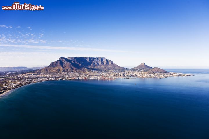 Immagine Baia di Cape Town e Table Mountain, Sudafrica - Cape Town non è particolare solo per il fatto che rappresenta la punta più a sud dell'Africa, ma anche perché al suo interno si lascia abbracciare dal complesso montuoso di Table Mountain. Quando questa imponente montagna incontra la dolcezza della Baia, il tutto condito dalla vastità dell'oceano atlantico, l'effetto finale è magnifico - © michaeljung / Shutterstock.com