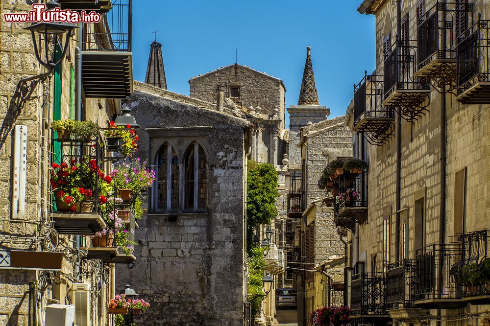 Immagine Balconi fioriti nelle stradine medievali di Petralia Soprana, provincia di Palermo, Sicilia. Sullo sfondo, le guglie della chiesa di Santa Maria.