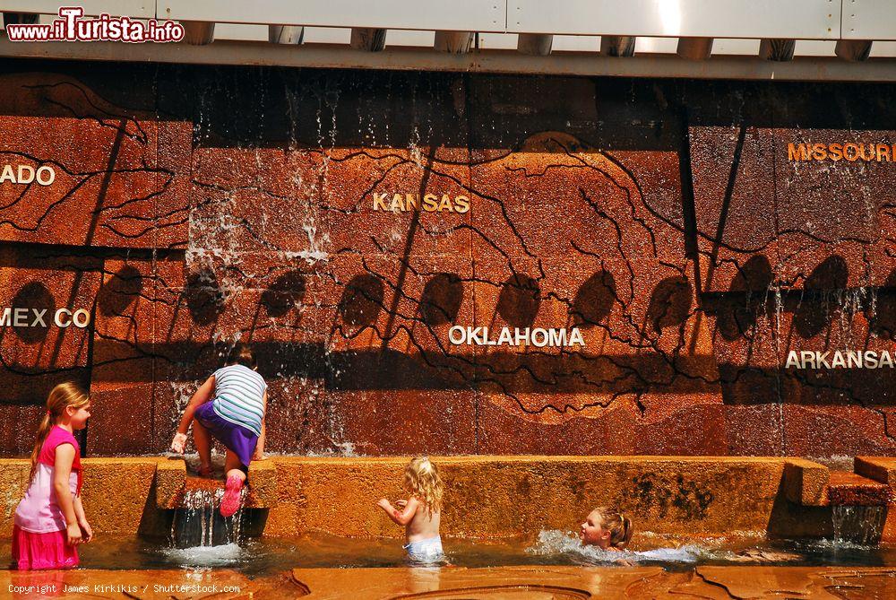 Immagine Bambini giocano in una fontana d'acqua in un parco di Mud Island a Memphis (Tennessee). La scultura rappresenta lo spartiacque del fiume Mississipi - © James Kirkikis / Shutterstock.com