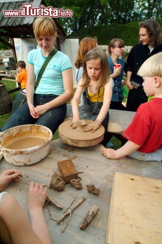 Immagine Bambini modellano vasi in argilla a Kernave durante la manifestazione dedicata all'archeologia (Lituania).