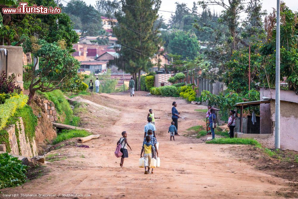 Immagine Bambini ruandesi a Kigali portano acqua dalla pompa pubblica in una strada residenziale - © Stephanie Braconnier / Shutterstock.com