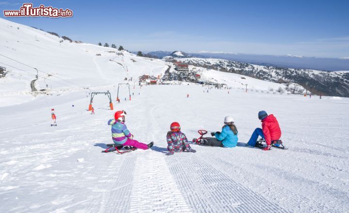 Immagine Bambini sulle piste di Sappada, Veneto - Isola linguistica germanofona, questa città della provincia di Belluno è una nota stazione turistica estiva e invernale: nel 2007 ha ricevuto il marchio di qualità "bandiera arancione" conferito dal Touring Club Italiano ai piccoli Comuni dell'entroterra italiano con meno di 15 mila abitanti che si distinguono per un'accoglienza di qualità. Sui pendii di Sappada le prime seggiovie risalgono agli anni quaranta: oggi, a distanza di decenni, le piste di questa località circondata dai massicci dolomitici sono fra le più frequentate da sciatori e famiglie © kostasgr / Shutterstock.com