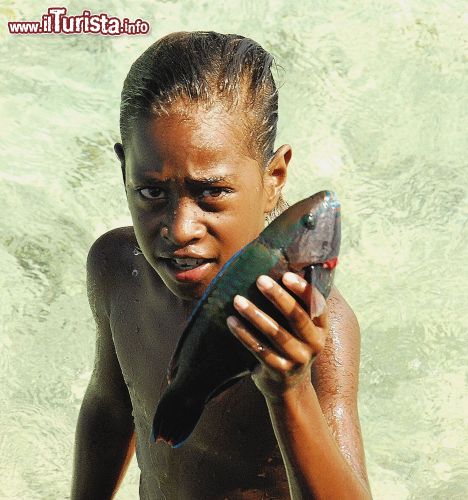 Immagine Bambino con pesce a Ouva, isola dell'arcipelago della Nuova Caledonia, Oceania.