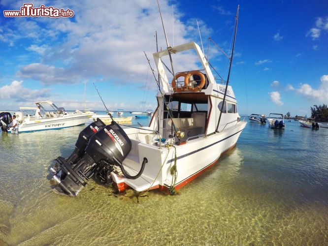 Immagine Barca da pesca d'altura a Flic en Flac, isola di Mauritius - Il Vagabond 3, un'imbarcazione utilizzata per la pesca d'altura, ormeggiato nel porto di Flic en Flac. E' alimentato da due potenti motori Suzuki © Kletr / Shutterstock.com