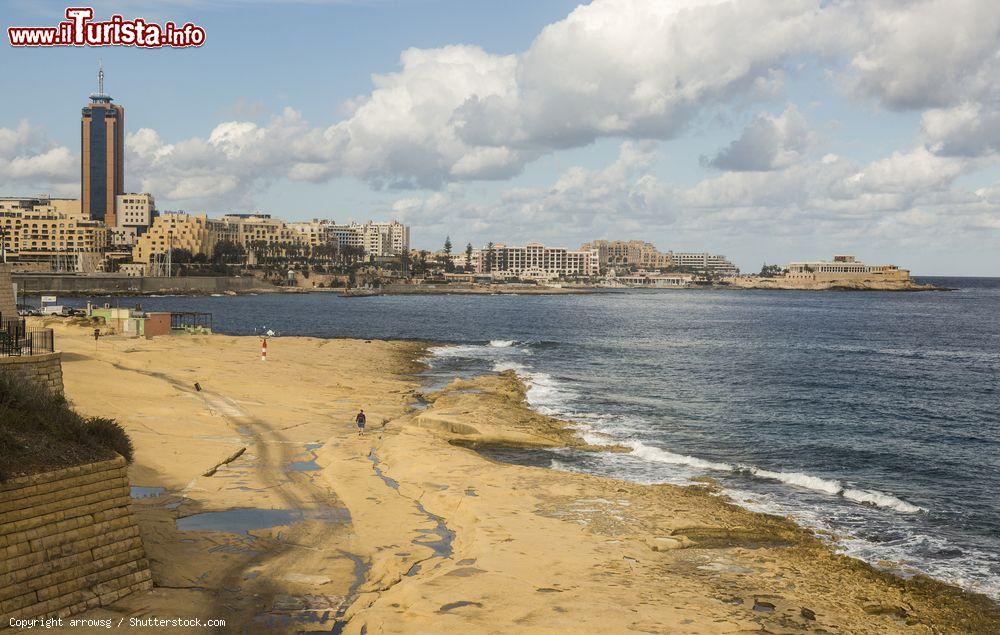 Immagine Battigia di rocce piatte durante la bassa marea a Sliema, Malta. A fare da cornice Paceville e la baia di San Giuliano - © arrowsg / Shutterstock.com