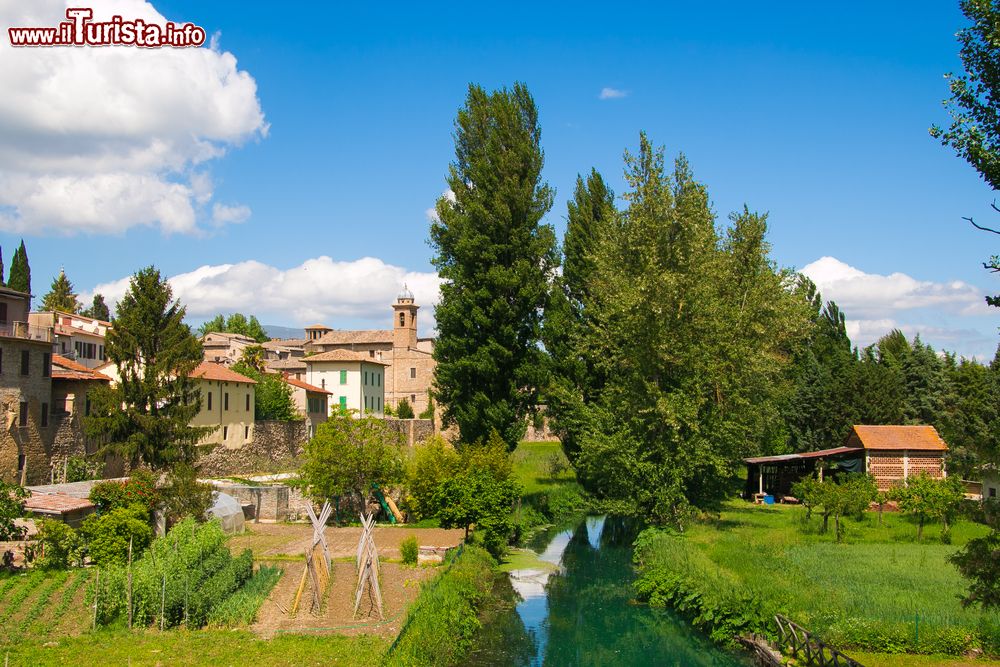 Immagine Bevagna vista dal ponte sul fiume Clitunno, Umbria. Un bel panorama con le mura cittadine e la vegetazione che la circonda.