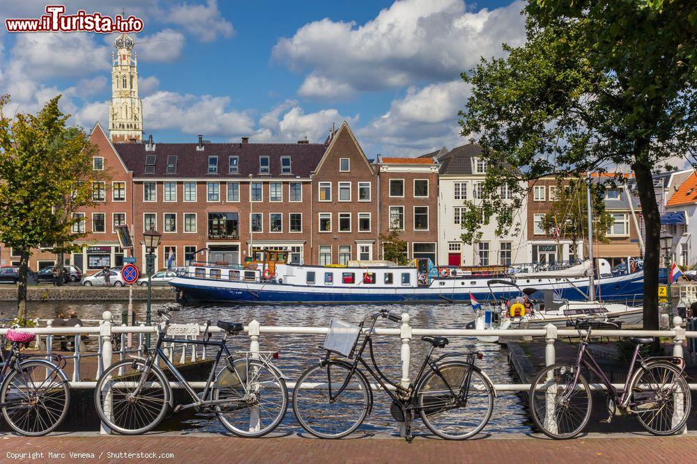 Immagine Biciclette parcheggiate lungo la ringhiera di un ponte a Haarlem, Olanda. Sullo sfondo, un'imbarcazione blu sul canale - © Marc Venema / Shutterstock.com