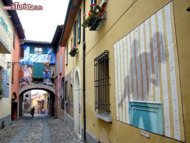 Immagine Pellegrini, Pozzati, Tadini e Sassu sono solo alcuni degli importanti artisti che hanno firmato le opere che arricchiscono le vie del centro storico di Dozza. Dal 1960 grandi maestri della pittura hanno realizzato sui muri di questo borgo medievale grandi affreschi che hanno contribuito a elevare culturalmente e artisticamente Dozza trasformandola nella capitale dell'affresco moderno - © www.fondazionedozza.it/