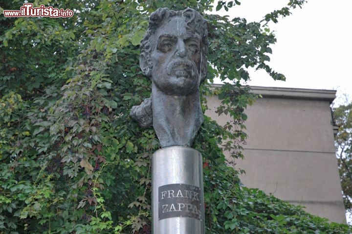 Immagine Monumento a Frank Zappa a Vilnius - Sono molti i turisti che visitano il centro di Vilnius, e che rimangono interdetti quando si imbattono nella statua dedicata a Frank Zappa, nel quartiere di Uzupis. E la domanda sorge spontanea: cosa c'entra la rock star americana con la capitale della Lituania? Nulla, tutto risale al 1995 quando successivamente alla caduta del muro di Berlino, dei cittadini guidati da Saulius Paukštys pensarono di installare il busto di Frank Zappa (scomparso nel 1993) sopra ad una colonna che aveva fino ad allora sorretto la figura di Lenin. Non c'era un motivo serio, solo il piacere e la passione per la sua geniale musica e quel brivido trasgressivo che solo il rock poteva dare a chi aveva subito decenni di comunismo e dominazione sovietica. Fatto sta che da quasi vent'anni Frank guarda beffardo i turisti che vengono ad ammirare il centro barocco di Vilnius!