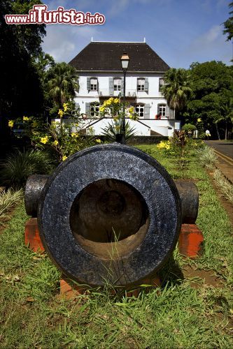 Immagine Cannone al museo navale di Mahebourg, Mauritius - Ospitato in un antico palazzo coloniale costruito attorno al 1771 con un ampio portico sul davanti, il museo navale dell'isola di Mauritius si trova nei pressi della strada di Curepipe. Un tempo di proprietà di Jean Robillard, le cui iniziali si possono ancora leggere sulla ringhiera di ferro battuto e che la utilizzò come ospedale militare per curare i feriti, l'edificio fu poi acquistato nel 1950 dal governo coloniale che lo ripristinò per trasformarlo nella sede dell'attuale museo: la maggior parte degli oggetti qui conservati sono legati alla storia navale e marittima di Mauritius © lkpro / Shutterstock.com