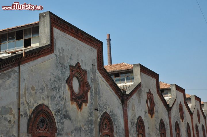 Immagine I capannoni del Cotonificio Crespi: culla del villaggio ideale - i capannoni a shed del Cotonificio Crespi furono costruiti, insieme alla ciminiera e all'edificio principale, nel 1876, disposti in linea orizzontale su quella che divenne la via principale del villaggio operaio di Crespi d'Adda. All'interno di questi maestosi capannoni che, nonostante lo stile rigorosamente industriale non rinunciano a un tocco di eleganza di ispirazione gotica, avveniva il fulcro della produzione del cotonificio, grande potenza che dava costante linfa al villaggio e alle sue gloriose strutture. 