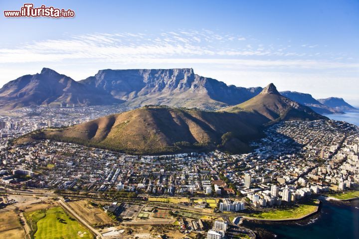 Immagine Panorama di Cape Town e le sue montagne, fotografata dall'aereo - Sembra quasi uno scherzo questo scenario fatto da una montagna che si è piazzata nel bel mezzo della capitale del Sudafrica, invece è vero. Un elemento naturale pittoresco così vivo, quando guardato dall'aereo fa proprio sgranare gli occhi, in quanto si riesce a vederlo in tutta la sua potenza visiva ed emotiva - © Andrea Willmore / Shutterstock.com