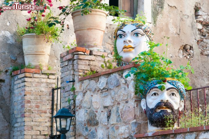 Immagine Caratteristici vasi a forma di testa incastonati nei muri di pietra lungo le vie di Castelmola, Sicilia.