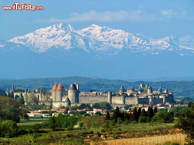 Immagine Panorama di Carcassonne, il borgo medievale nel sud della Francia, in una limpida giornata di sole: sullo sfondo, al di là delle mura e delle torri difensive della cittadella, si stagliano imponenti i Pirenei innevati - © Paul Palau