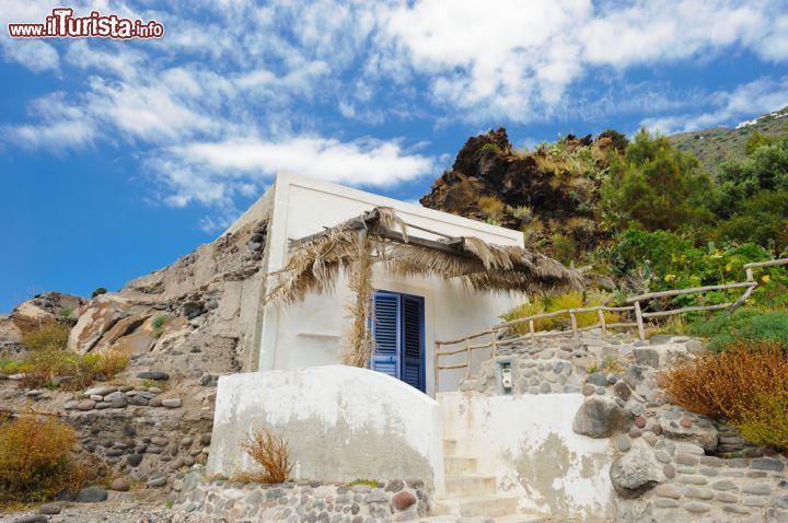 Immagine Casa costruita nella roccia a Alicudi, Sicilia - Passeggiando per l'isola se ne può scoprire l'interessante e caratteristica architettura con casette bianche e basse e scalinate irregolari che scivolano verso il mare. Fra le abitazioni più singolari ve ne sono alcune ricavate all'interno di formazioni rocciose come quella di questa immagine fotografica © EugeniaSt / Shutterstock.com