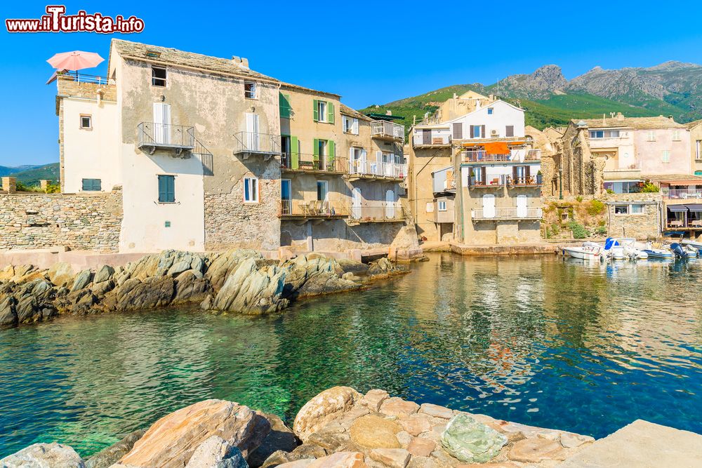 Immagine Case al porto di Erbalunga, Corsica, Francia. Sul bel porticciolo della città di mare si affacciano antiche case in pietra e numerosi ristoranti che cucinano specialità di pesce.