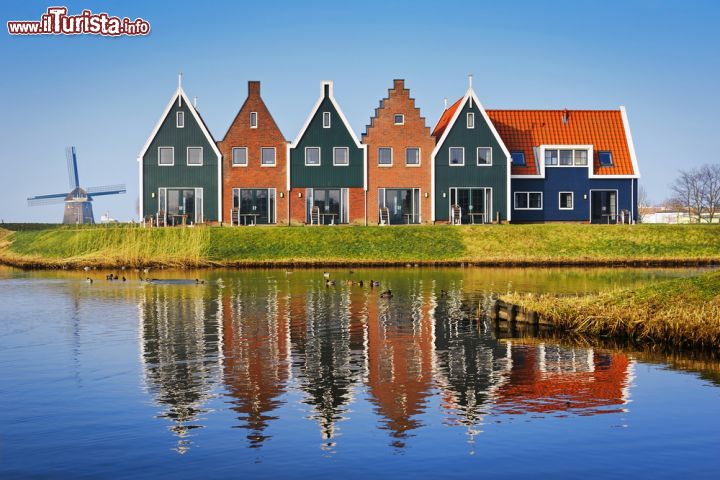 Immagine Le spettacolari case di Volendam, Olanda - Situata a circa 20 chilometri a nord-nord est di Amsterdam, Volendam è un villaggio con porto peschereccio della costa sud orientale dell'Olanda situato nella regione del Waterland. A rendere caratteristico questo borgo costiero, fra i più visitati dai turisti, sono i suoi suggestivi edifici dalle facciate variopinte con frontoni in legno e i tradizionali mulini a vento © Natalia Paklina / Shutterstock.com