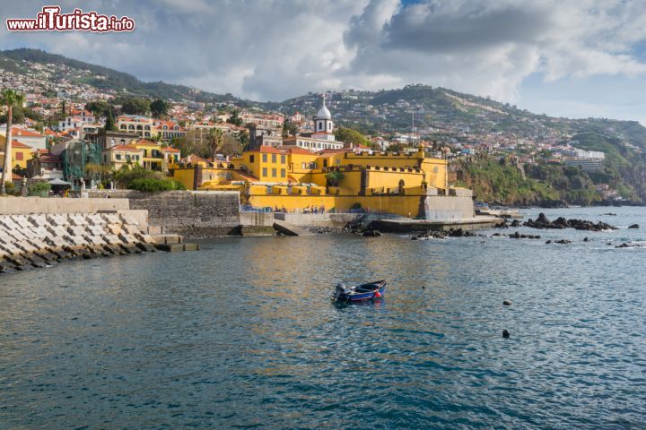 Immagine Il Castello Sao Tiago a Funchal, Madeira (Portogallo) - Non si presenta con l'architettura tipica delle fortezze, nè nei colori nè nelle sembianze eppure, il castello Sao Tiago, rappresenta il polo più pittoresco della capitale. Si trova alla fine della passeggiata di Santa Maria e diversamente da altri edifici, non solo si può visitare ma si può anche pranzare o cenare nel tipico ristorante al suo interno. Inoltre, oggi è sede del Museo d'Arte Contemporanea e, visto il suo colore sgargiante che come si può vedere dall'immagine trionfa sull'intero paesaggio, non poteva esserci sede migliore - © Alberto Loyo / Shutterstock.com