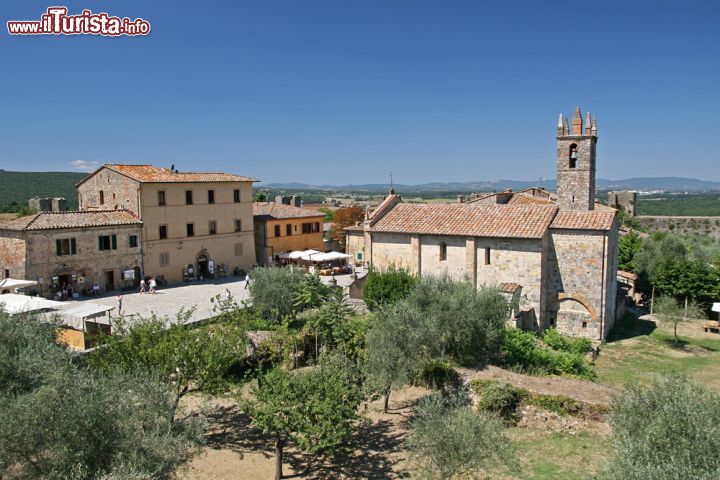 Immagine Veduta del centro di Monteriggioni, Toscana (Italia) - Il centro di Monteriggioni ha una conformazione urbana che non stona assolutamente con tutto il resto del circondario, anzi, gli regala un'emozione in più. Oltre a Piazza Roma si erge la chiesa di Santa Maria, come si vede dall'immagine riconoscibile dal campanile. Nel circondario, una natura bellissima fatta di giardini e orti, pieni di vigneti e olivi - © LensTravel / Shutterstock.com