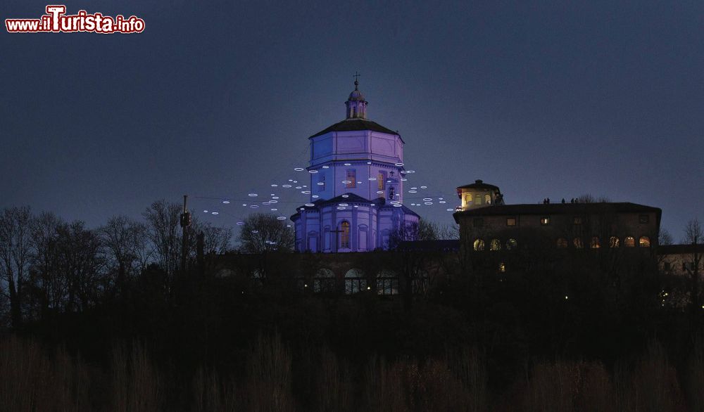 Immagine La chiesa di Santa Maria del Monte dei Cappuccini a Torino, Piemonte, by night. Alla fine del XVI° secolo fu il duca Carlo Emanuele I° a donare ai padri cappuccini il terreno del monte perchè vi fosse costruito un edificio sacro. Un secolo più tardi vide la luce la chiesa in stile spiccatamente barocco. In questa immagine, un'opera luninosa di Rebecca Horn.