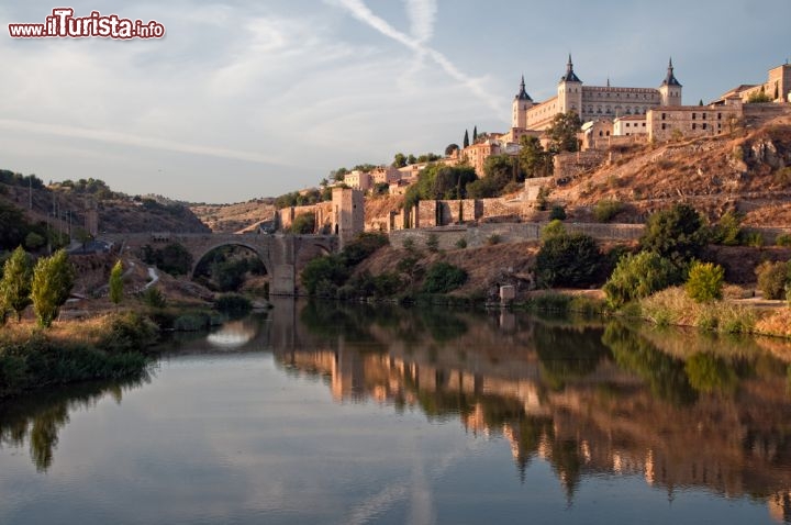 Immagine L'antico borgo di Toledo visto dal fiume Tago, con il Ponte di Alcàntara sullo sfondo e le tipiche sfumature rosate della luce pomeridiana - La Mancia Spagna 122279812 - © Gitanna / Shutterstock.com