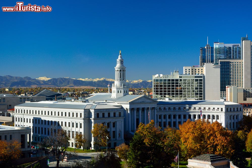 Immagine Colorado City Hall a Denver, Stati Uniti. Il bel Municipio cittadino fotografato con le Montagne Rocciose sullo sfondo e gli alberi in versione autunnale in primo piano.