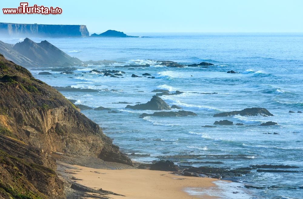 Immagine Costa atlantica e spiaggia di Carriagem con la bassa marea fotografate in una mattina d'estate a Aljezur, Portogallo.