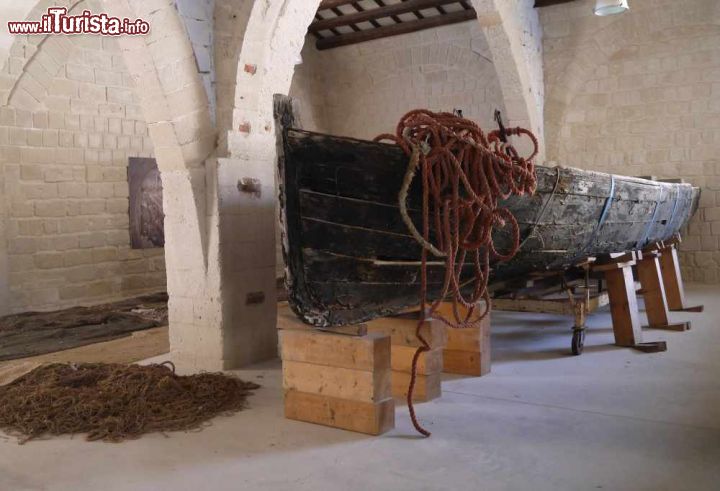 Immagine Barca nella tonnara di Favignana, Sicilia. Una storica barca da pesca e le reti dei pescatori all'interno dell'antica tonnara di Favignana che con i suoi 32 mila metri quadrati è una delle più grandi del Mediterraneo. E' conosciuta anche come Ex Stabilimento delle tonnare di Favignana e Formica - © Deborah Terrin