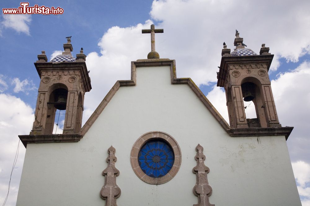 Immagine Dettaglio architettonico di una chiesa con due campanili a Morelia, Messico. La facciata realizzata con intonaco bianco è impreziosita dal rosone con vetri blu.