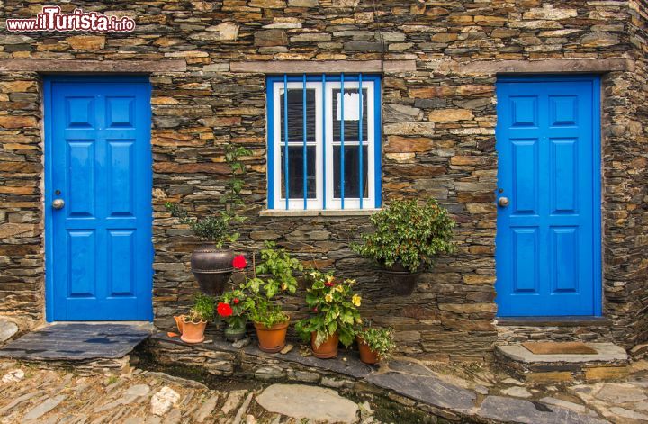 Immagine Dettaglio di una vecchia casa in pietra a Piodao, Portogallo - La roccia con cui sono costruite le case di Piodao incornicia le belle porte azzurre tipiche di tutte le abitazioni di questo villaggio © Carlos Caetano / Shutterstock.com
