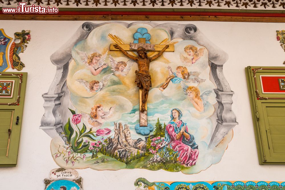 Immagine Un dipinto religioso con croce in legno sulla facciata di una casa a Canazei, Val di Fassa, Trentino Alto Adige.