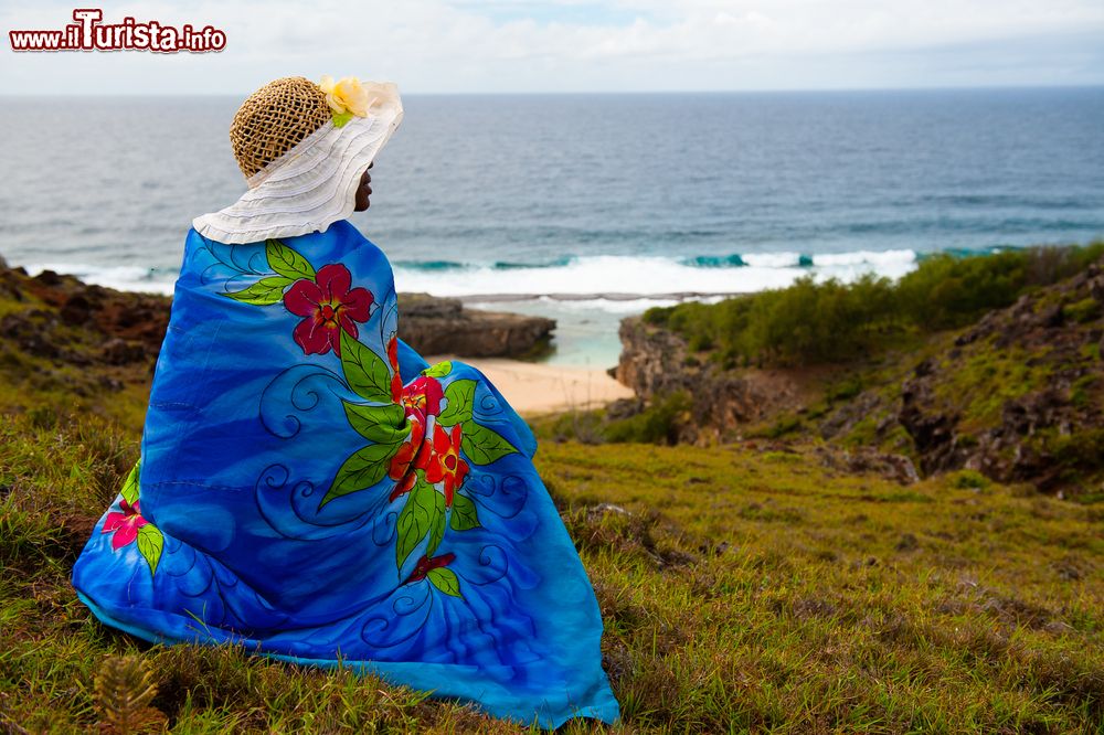Immagine Una donna con il cappello intenta a guardare l'oceano sull'isola di Rodrigues, Repubblica di Mauritius. Quest'isola verdissima è circondata da una laguna di barriera corallina che si estende per alcuni km quadrati.
