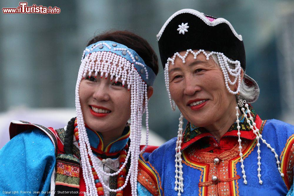 Immagine Donne di etnia mongola indossano i tradizionali abiti durante il Naadam a Ulan Bator, Mongolia.
Questa tipica festività nazionale che si svolge a metà luglio è inserita nell'elenco dei patrimoni culturali dell'umanità - © Pierre Jean Durieu / Shutterstock.com