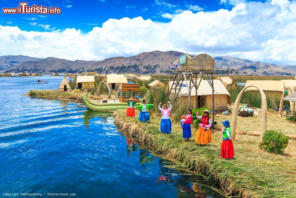 Immagine Donne in costume tradizionale accolgono i turisti sull'isola di Uros in Perù, lago Titicaca - © Pakhnyushchy / Shutterstock.com