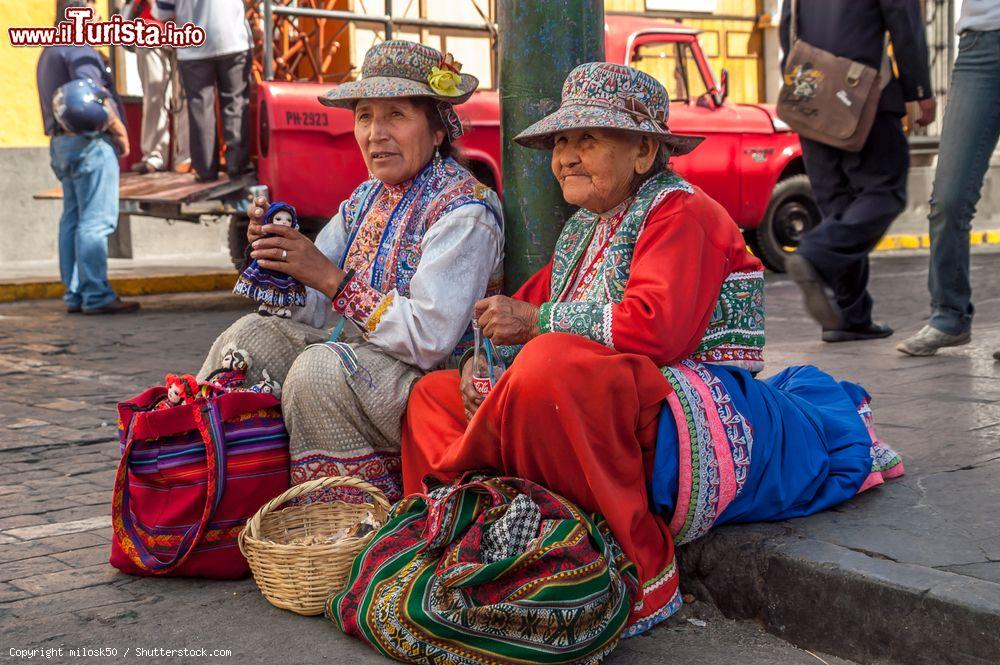 Immagine Donne sedute su un marciapiede intente a vendere bambole fatte a mano a Arequipa, Perù - © milosk50 / Shutterstock.com