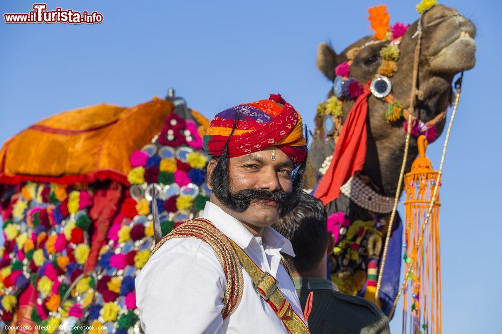 Immagine Un dromedario con un indiano con tipici abiti del Rajasthan durante il Festival del Deserto - © OlegD / Shutterstock.com