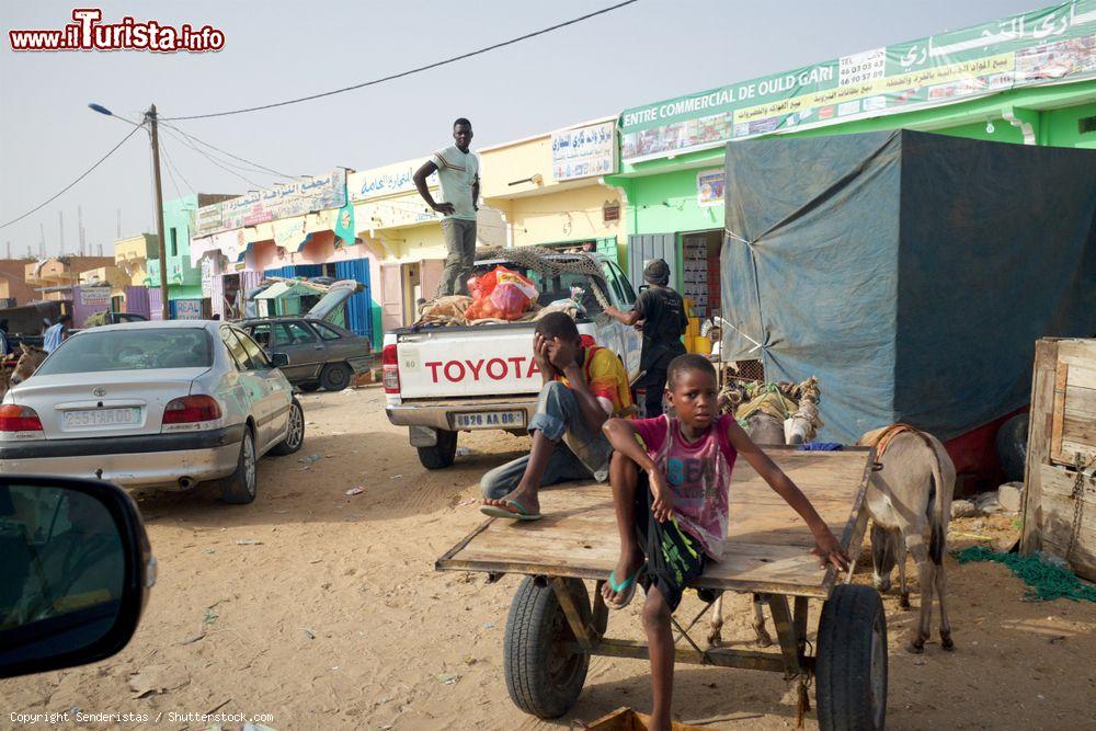 Immagine Due bambini seduti su un carretto traianto da asini in un quartiere di Nouakchott, Mauritania - © Senderistas / Shutterstock.com