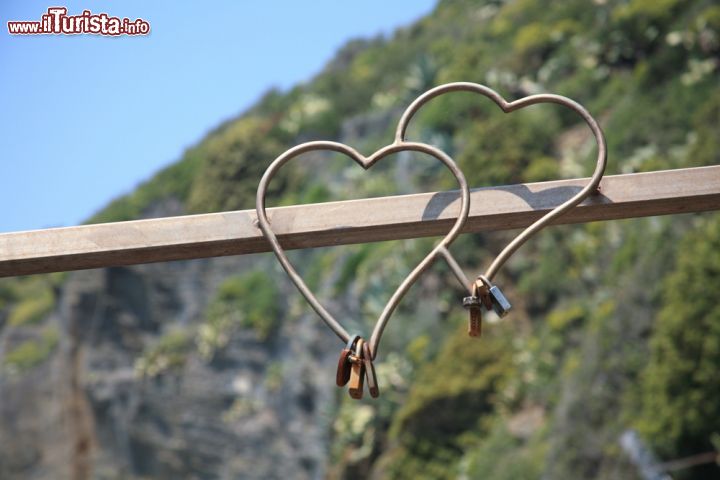 Immagine Due cuori con lucchetti lungo la Via dell'Amore a Manarola, Cinque Terre, Liguria. Questa strada pedonale a picco sul mare congiunge tramite un km di tracciato i borghi di Manarola e Riomaggiore.