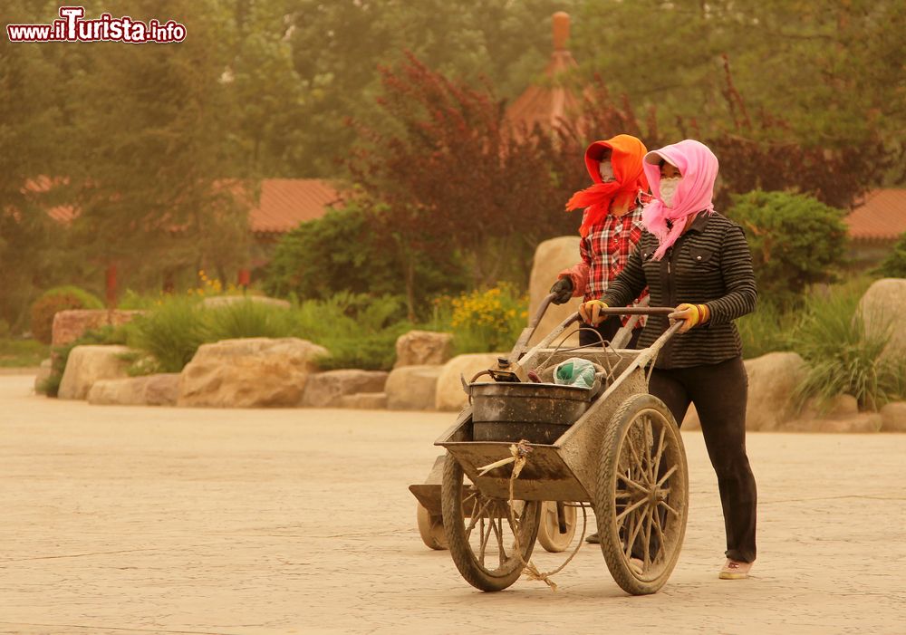Immagine Due donne camminano per strada durante una tepesta di sabbia a Yinchuan, Cina.