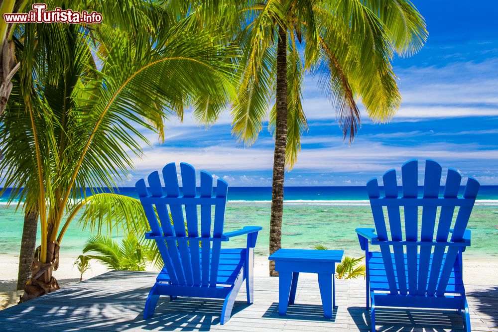 Immagine Due sedie in legno dipinte di blu su una spiaggia delle Isole Cook, Polinesia.