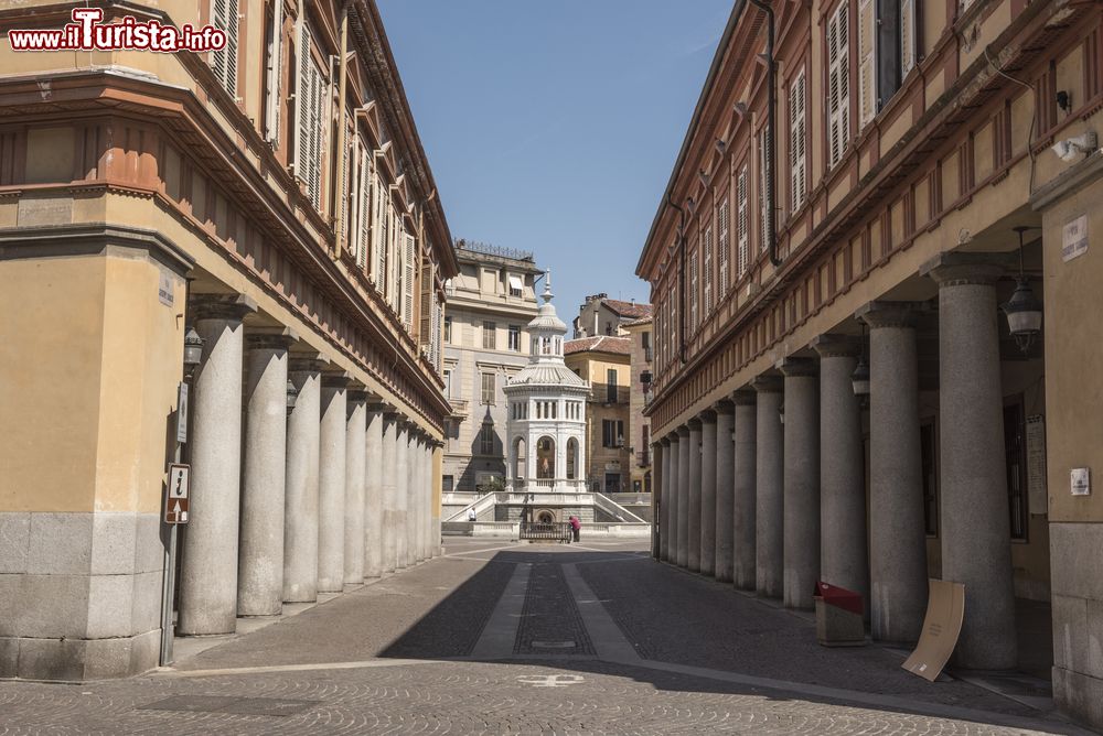 Immagine Edicola votiva nella parte antica di Acqui Terme vista da una via lastricata con portici, Piemonte.