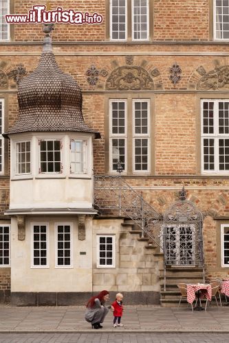 Immagine Aalborg, Danimarca: una mamma con il suo bambino di fronte a un vecchio edificio, ora restaurato, del centro storico della città - foto © Ms Jane Campbell / Shutterstock.com